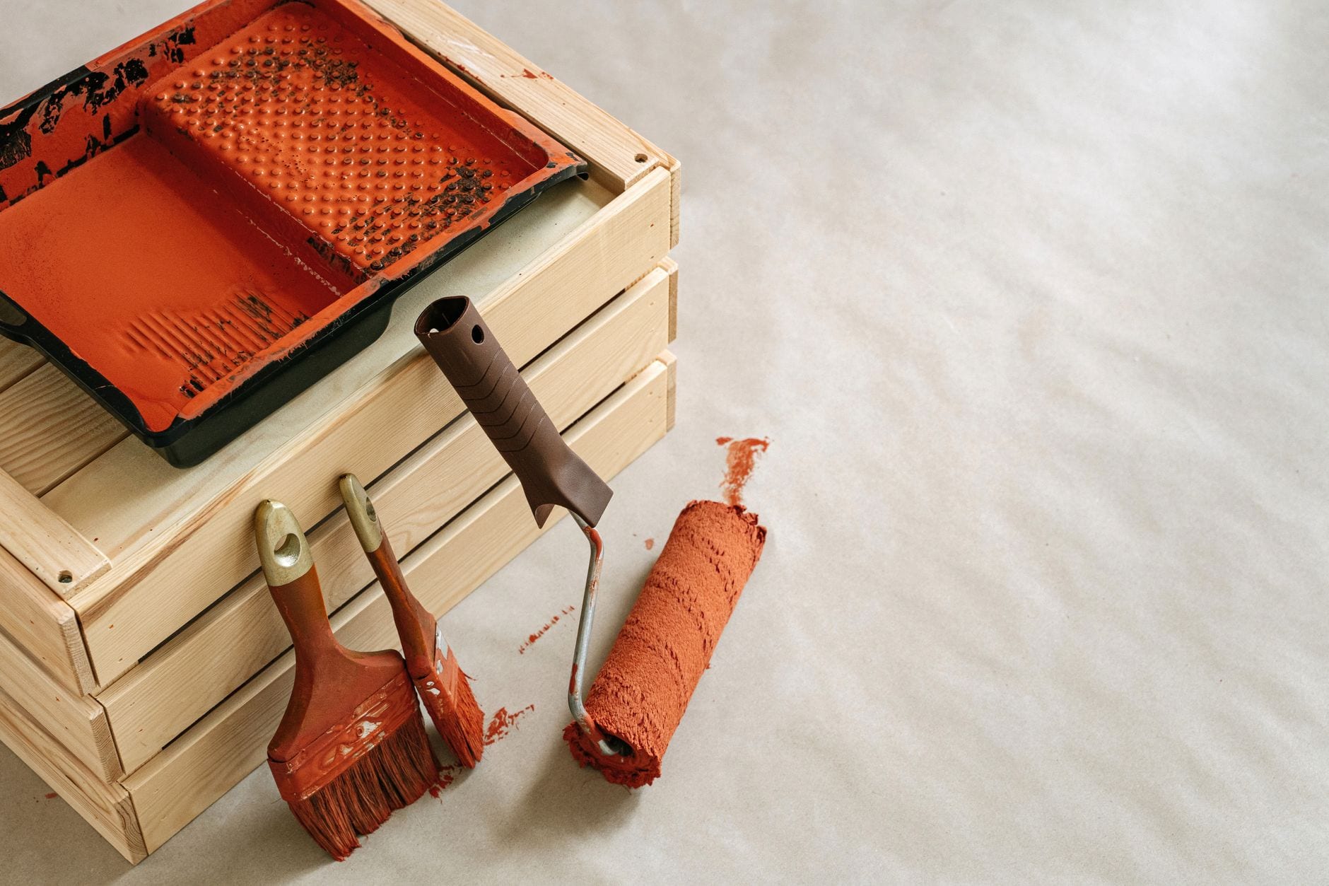 Painting tools, brushes, roller and tray, laid out for an interior painting job